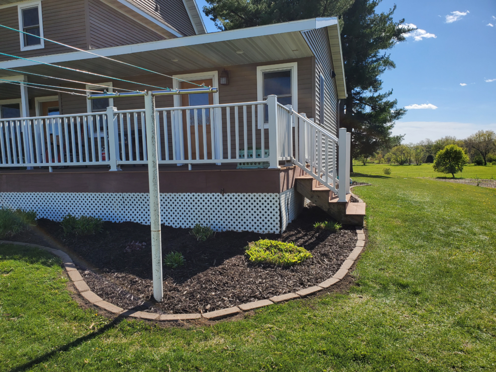 A beautifully landscaped front entryway in Eau Claire featuring decorative rock beds, a clean retaining wall, and a green lawn.